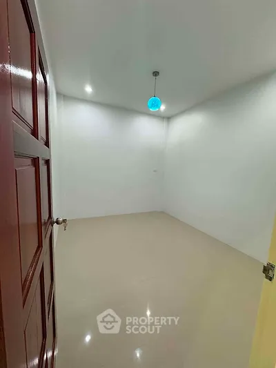 Spacious empty room with glossy floor and modern lighting, perfect for customization.