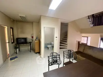 Cozy living area with staircase and compact kitchen setup