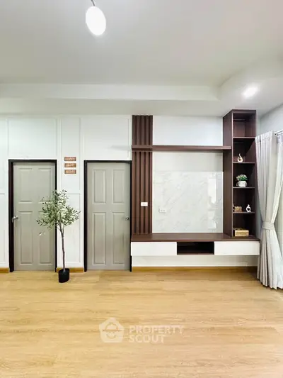 Modern living room with elegant wooden flooring and built-in shelving unit.