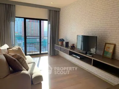 Spacious living room with modern decor and large window offering city views.