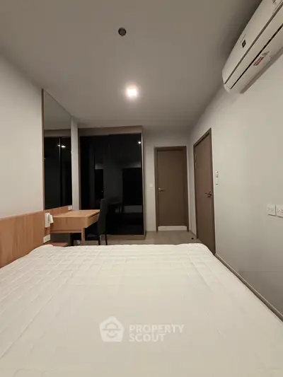 Modern bedroom with minimalist design and air conditioning in a contemporary apartment.