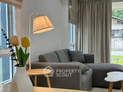 Cozy living room with modern gray sofa and stylish lamp, perfect for relaxation.