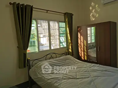 Cozy bedroom with natural light, featuring a stylish bed and wardrobe, perfect for relaxation.