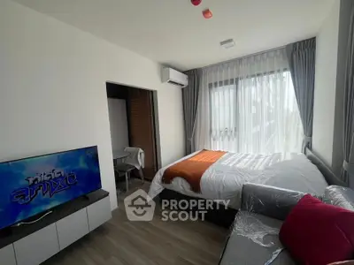 Modern bedroom with large windows, stylish decor, and natural light in a contemporary apartment.