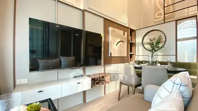 Modern living room with sleek TV and stylish dining area in open layout.