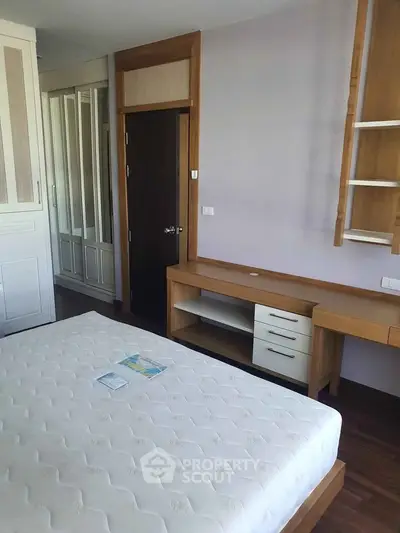 Spacious bedroom with modern wooden furniture and built-in wardrobe