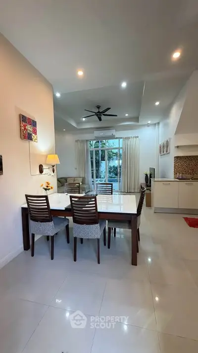 Elegant dining area with modern furniture and open kitchen layout, perfect for family gatherings.