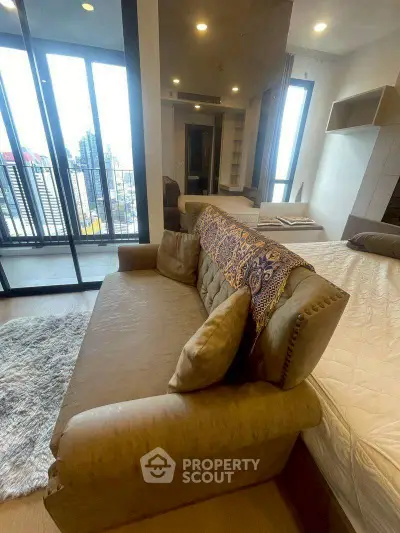 Stylish modern living room with cozy sofa and city view balcony in luxury apartment.