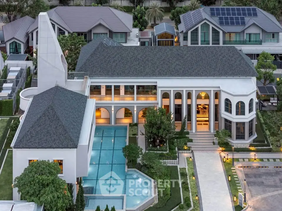 Luxurious mansion with grand architecture and stunning pool in upscale neighborhood.