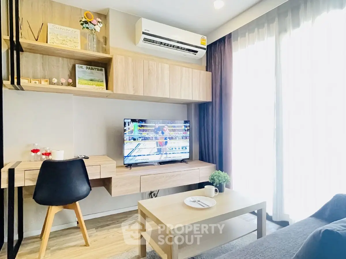 Modern living room with stylish furniture and wall-mounted TV, featuring natural light and cozy ambiance.