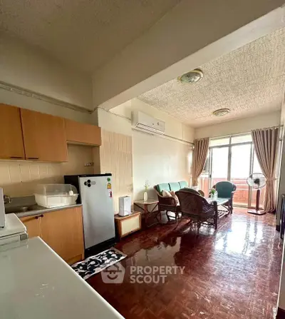 Cozy living room with natural light and modern furniture in an open layout apartment.