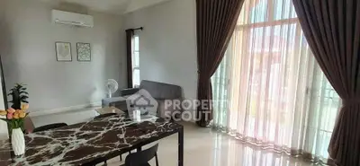 Spacious living room with elegant marble table and large windows for natural light.