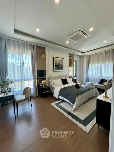 Luxurious bedroom with elegant decor and large windows offering natural light