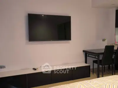 Modern bedroom with wall-mounted TV and sleek black furniture