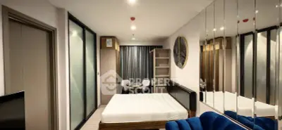 Modern bedroom with mirrored wall and cozy seating area in a stylish apartment.