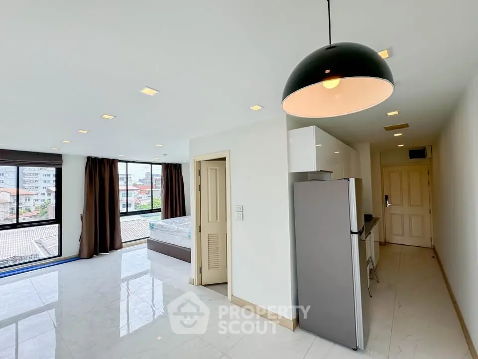 Spacious modern apartment with open layout and large windows offering city views.