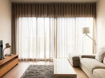 Bright and airy living room with modern furniture and floor-to-ceiling windows.