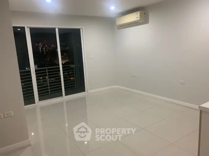 Spacious modern living room with large windows and city view, perfect for urban living.