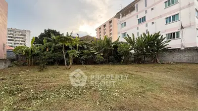 Spacious urban garden plot surrounded by residential buildings, ideal for development or landscaping.