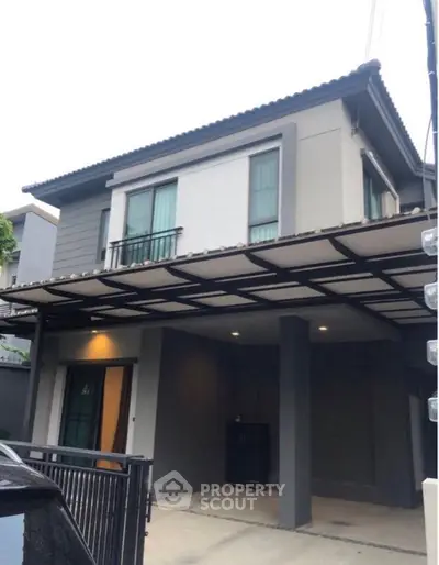 Elegant two-story home with a spacious covered parking area, featuring a modern design with clean lines and a welcoming entrance.