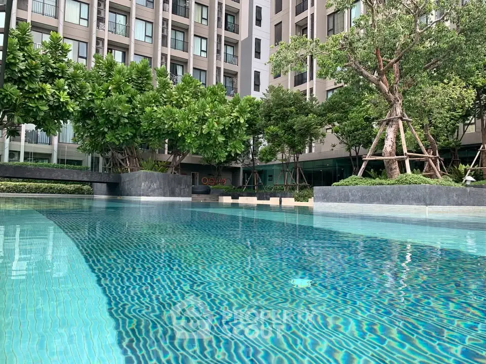 Luxurious condominium with serene pool and lush greenery, perfect for relaxation and modern living.