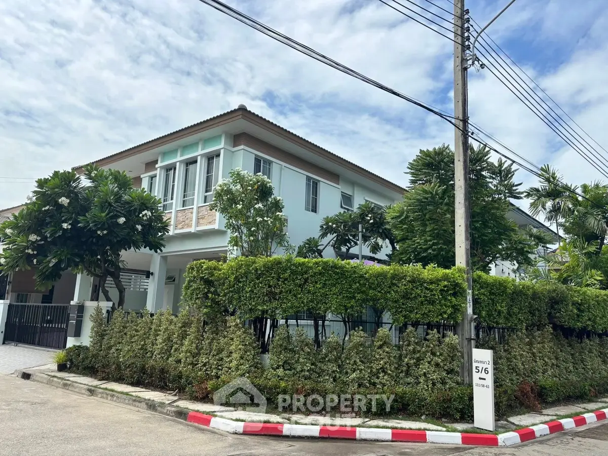 Charming two-story house with lush garden and modern architecture in a serene neighborhood.