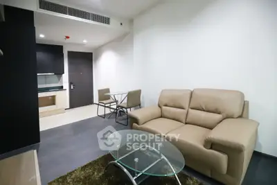 Modern living room with beige leather sofa and glass coffee table in a stylish apartment.
