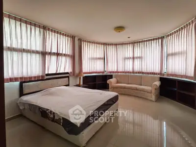 Spacious bedroom with large windows and elegant furnishings