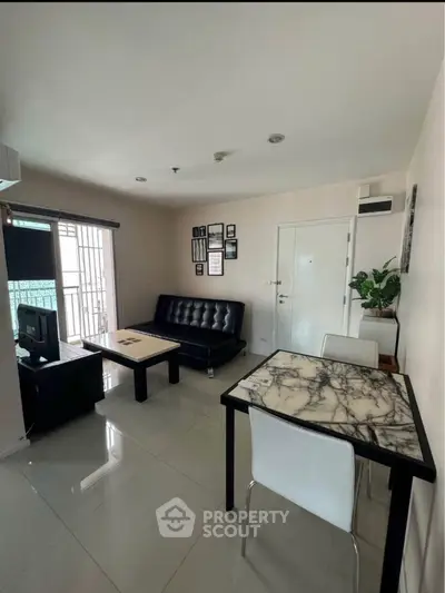 Modern living room with sleek black sofa and marble dining table in bright apartment