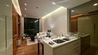 Luxurious modern living room with open kitchen, elegant decor, and ambient lighting.