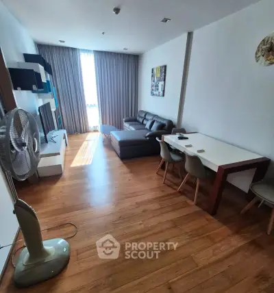 Spacious living room with modern furniture and wooden flooring, perfect for relaxation and entertainment.