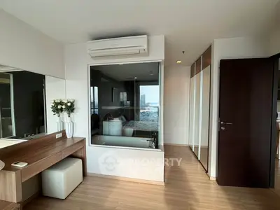 Modern bedroom with glass wall and city view, featuring sleek wooden flooring and built-in wardrobe.