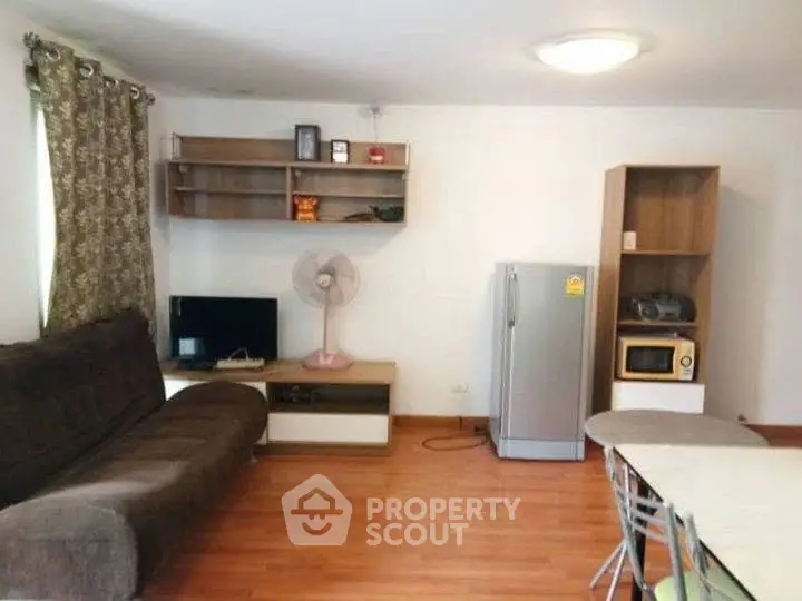 Spacious living room with modern furniture and appliances, perfect for comfortable living.