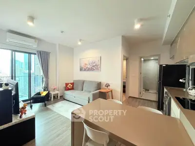 Modern open-plan living room with city view, featuring sleek kitchen and cozy seating area.