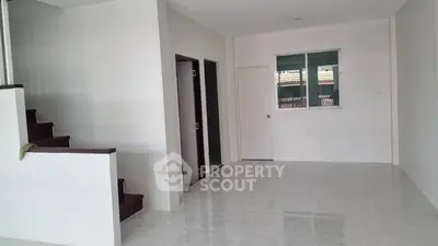 Spacious modern interior with staircase and tiled flooring, ideal for customization.