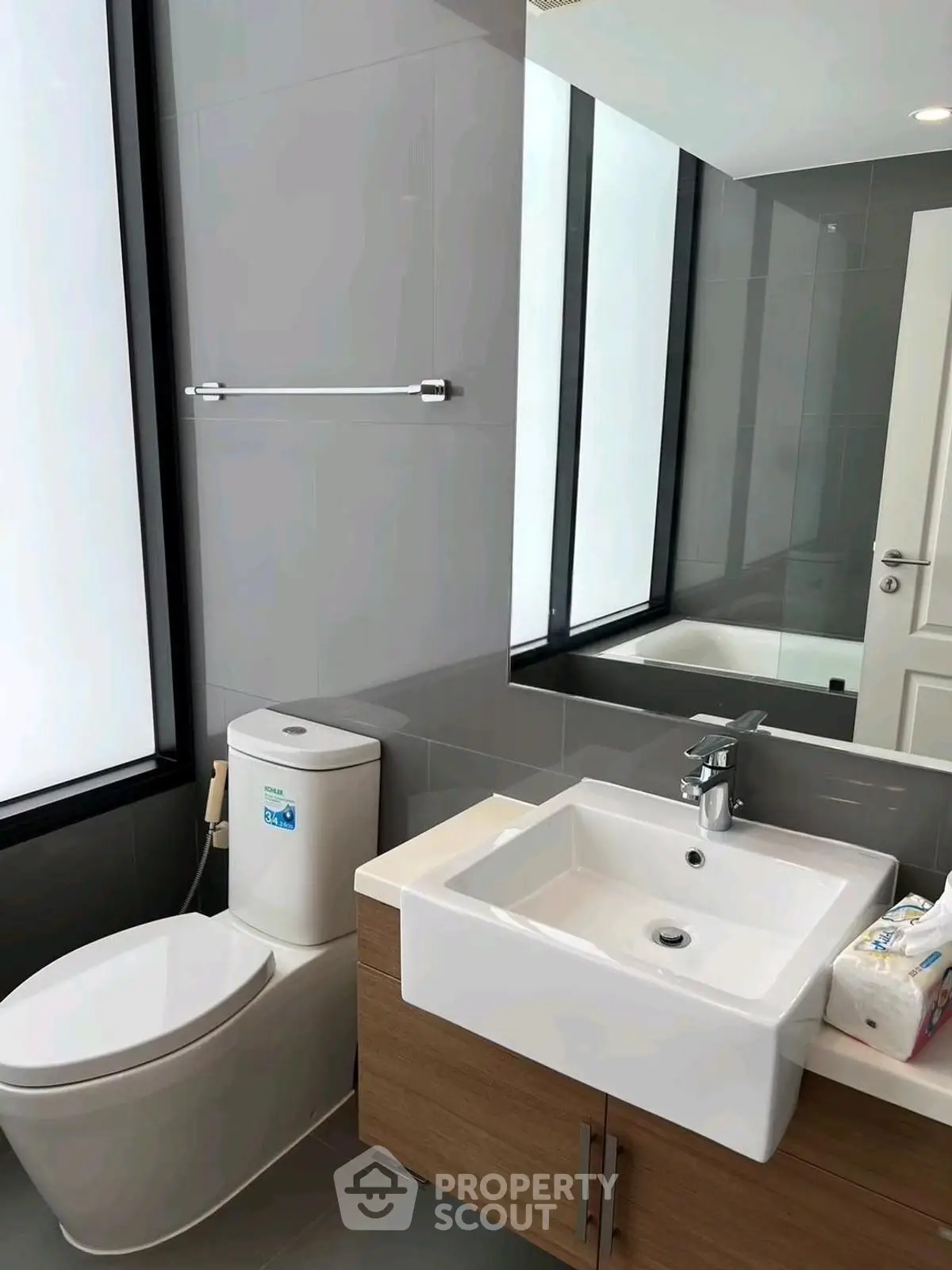 Modern bathroom with sleek fixtures and large mirror, perfect for contemporary living.