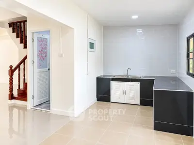 Modern kitchen with sleek black countertops and tiled backsplash in a bright, open space.