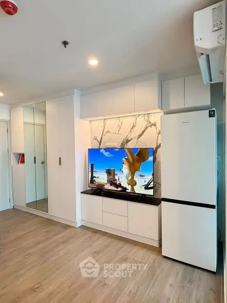 Modern living room with sleek built-in storage and stylish TV setup in a contemporary apartment.