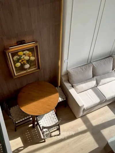 Stylish living room with cozy sofa and elegant round wooden table, perfect for modern living.