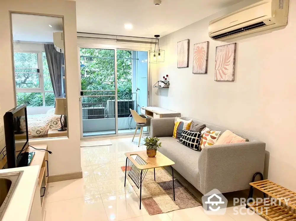 Modern living room with balcony view, stylish decor, and natural light in urban apartment.