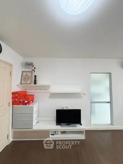 Modern living room with sleek TV setup and minimalist shelving