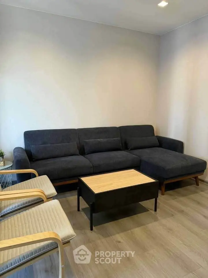 Modern living room with stylish dark sofa and wooden coffee table, perfect for cozy gatherings.