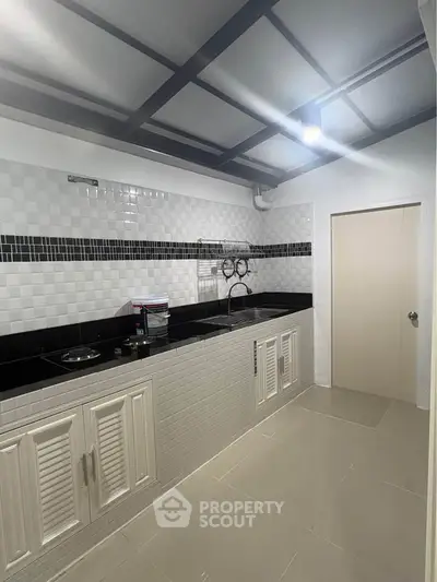 Modern kitchen with sleek black countertops and white cabinetry