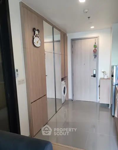 Modern apartment entrance with sleek storage and washing machine
