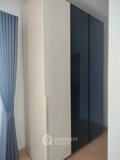 Modern bedroom with sleek wardrobe and elegant curtains