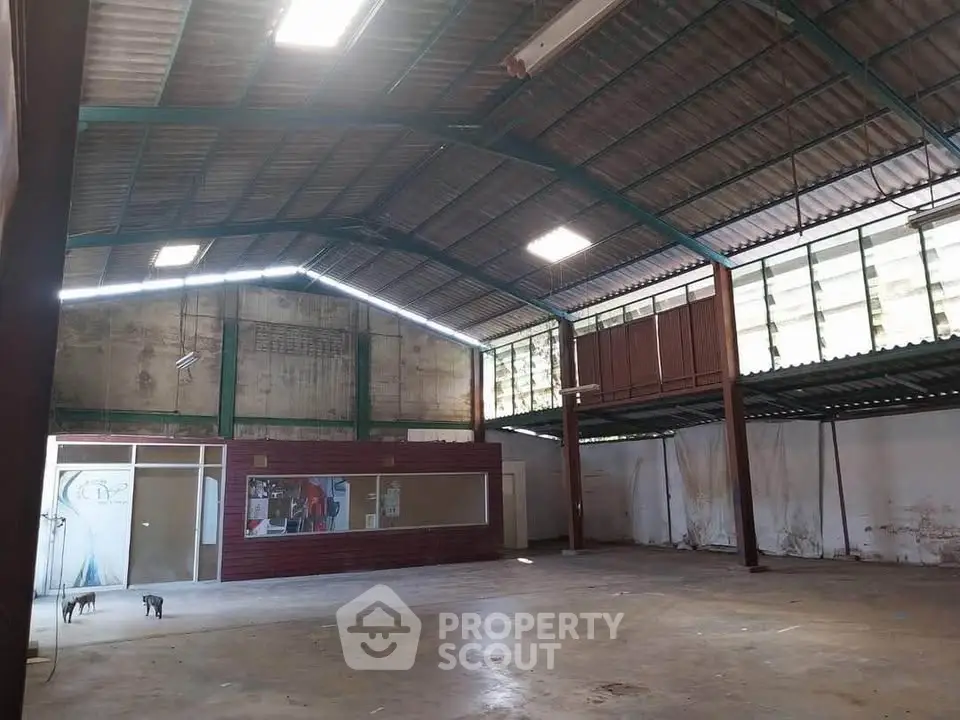 Spacious industrial warehouse with high ceilings and ample natural light.