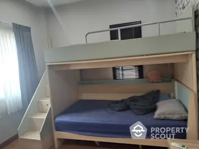 Cozy bedroom with bunk bed and natural light from window