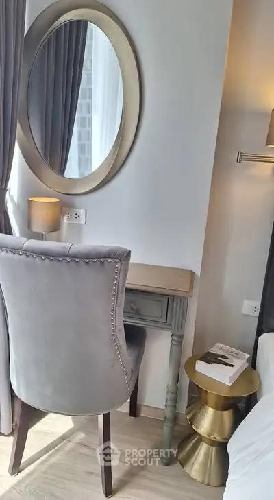 Elegant bedroom corner with stylish chair, mirror, and side table, perfect for a cozy reading nook.