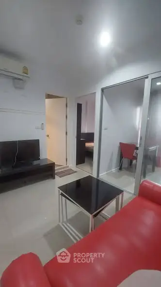 Modern living room with red sofa and sleek black coffee table in a stylish apartment.