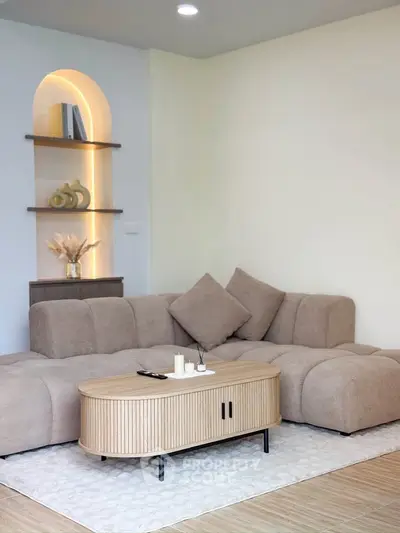 Modern living room with stylish beige sofa and elegant wooden coffee table